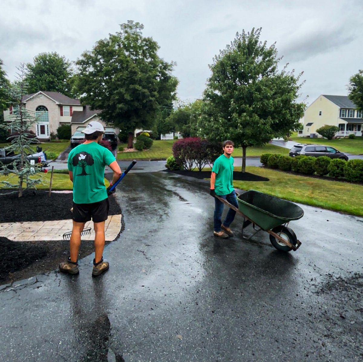 Serene Landscaping crew spreading mulch along a driveway bed