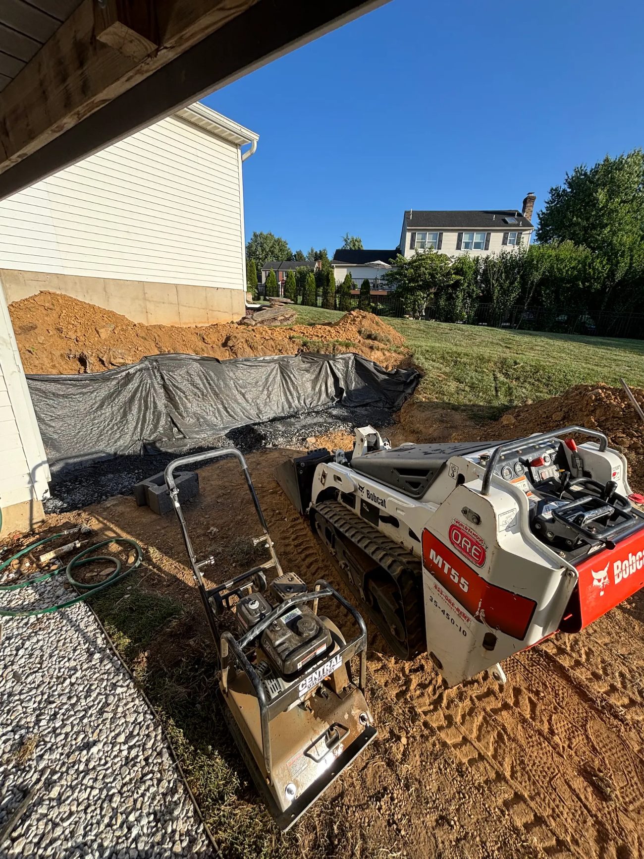 Compact track loader laying gravel base for a paver foundation