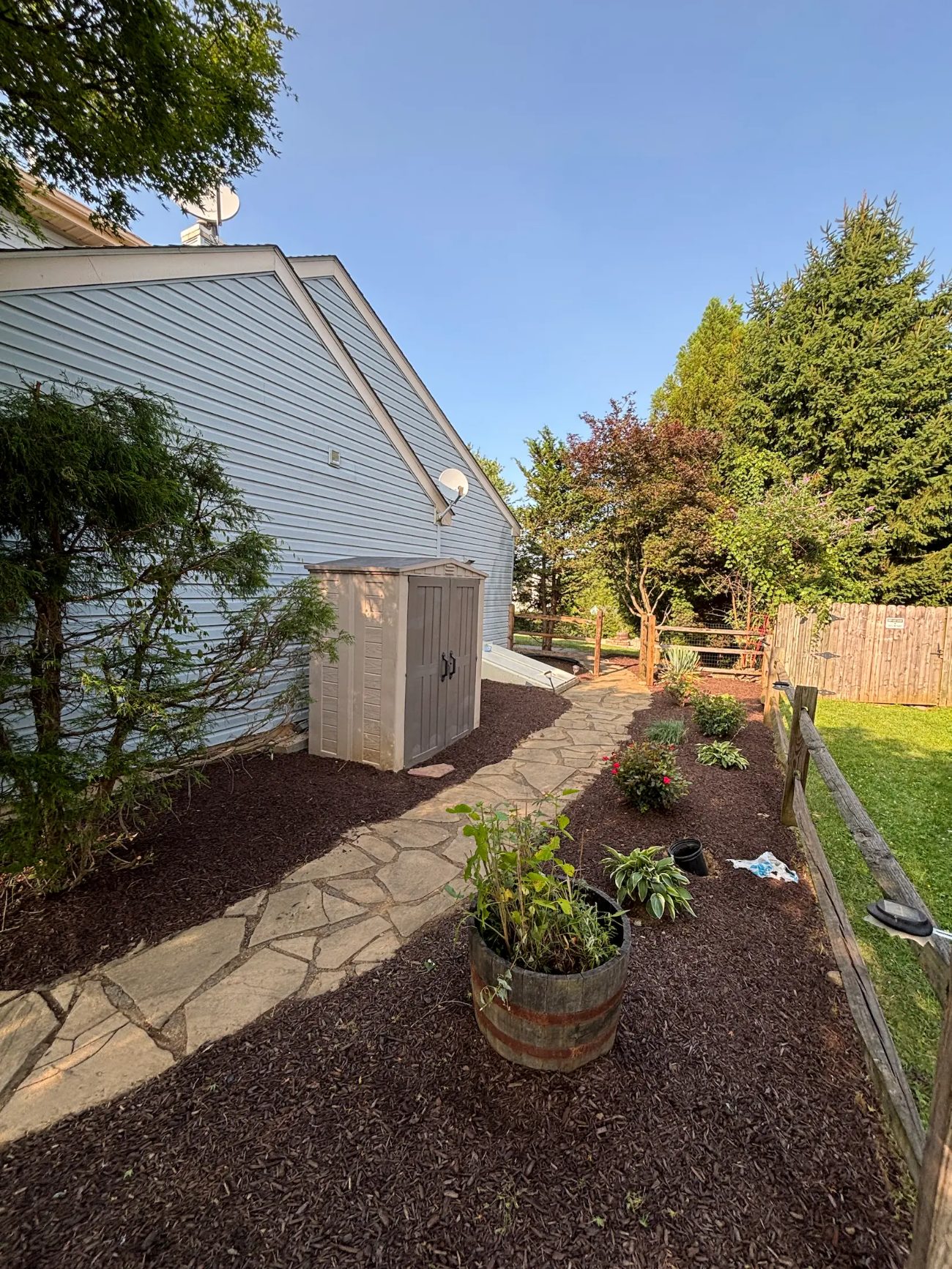 Flagstone walkway winding through fresh mulch beds and plantings